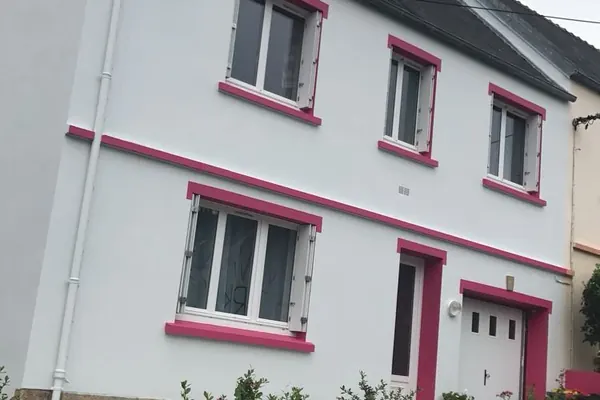 Maison ravalée en blanc avec encadrements peints en rose près de Brest